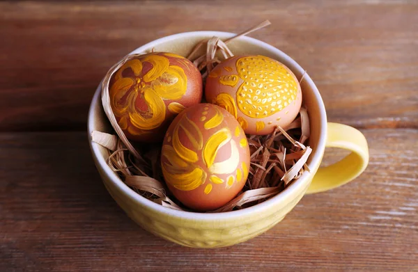 Huevos de Pascua en taza sobre fondo de madera — Foto de Stock