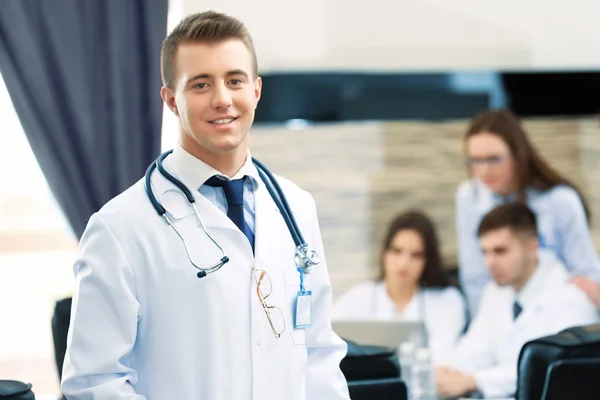 Attraktiver männlicher Arzt mit Team im Konferenzraum — Stockfoto