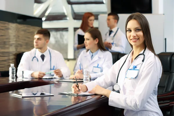 Mooie jonge dokter met team in vergaderruimte — Stockfoto