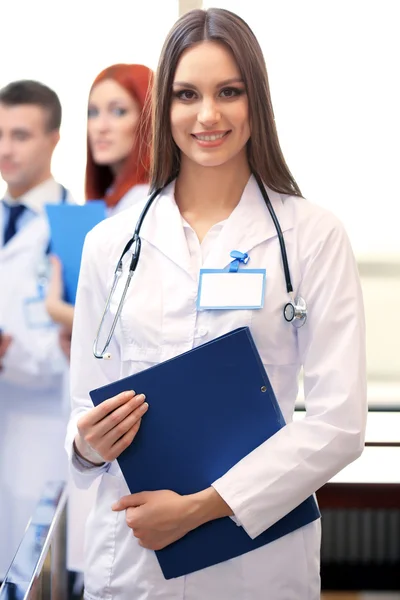 Schöne junge Ärztin mit Team im Konferenzraum — Stockfoto