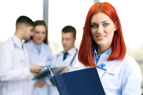 Jovem médico bonito com equipe na sala de conferências — Fotografia de Stock