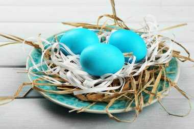 Plaka üzerinde ahşap masa arka plan üzerinde renkli yumurta ile Paskalya kompozisyon