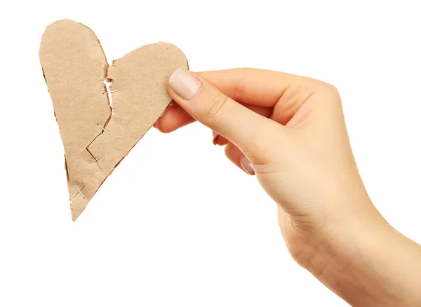 Mão feminina segurando coração partido costurado com grampos isolados em branco — Fotografia de Stock