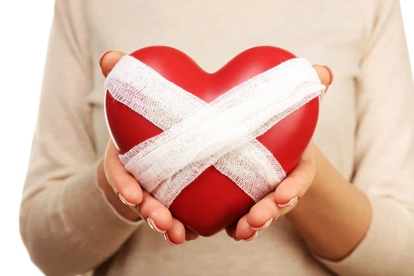 Mujer sosteniendo el corazón vendado de cerca — Foto de Stock