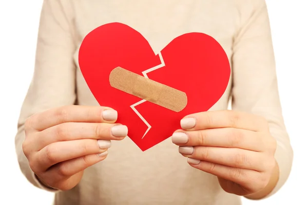 Woman holding broken heart with plaster close up — Stock Photo, Image