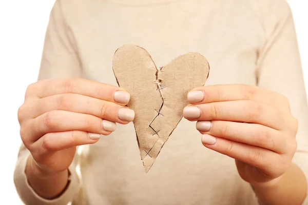 Woman holding broken heart stitched with staples close up — Stock Photo, Image