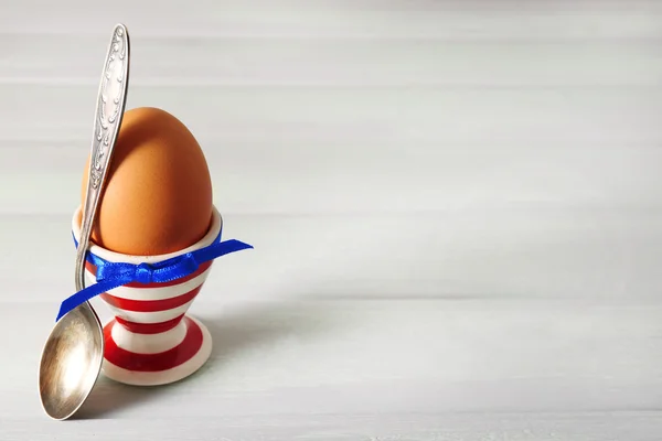 Boiled egg in holder on light background — Stock Photo, Image