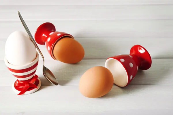 Boiled eggs in holders on light   background — Stock Photo, Image