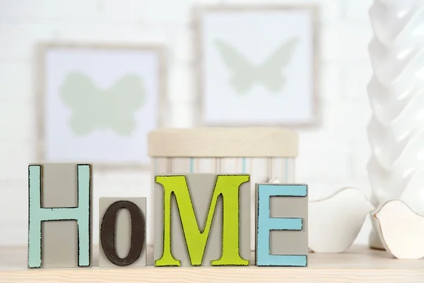 Thuis in kleurrijke brieven, in licht wit interieur, op houten plank — Stockfoto