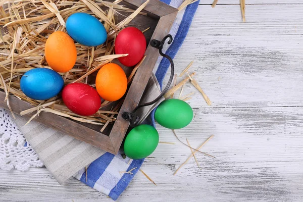 Easter eggs  on wooden tray, on colorful background — Stock Photo, Image