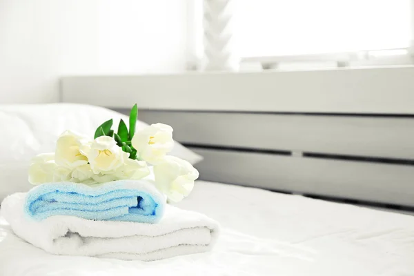 Bílé krásné tulipány na čisté ručníky v hotelu, zblízka — Stock fotografie