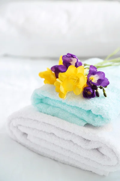 Colorful beautiful freesias on fresh towels in hotel, close up — Stock Photo, Image