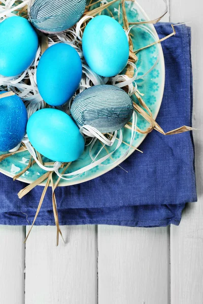 Plaka üzerinde ahşap masa arka plan üzerinde renkli yumurta ile Paskalya kompozisyon — Stok fotoğraf