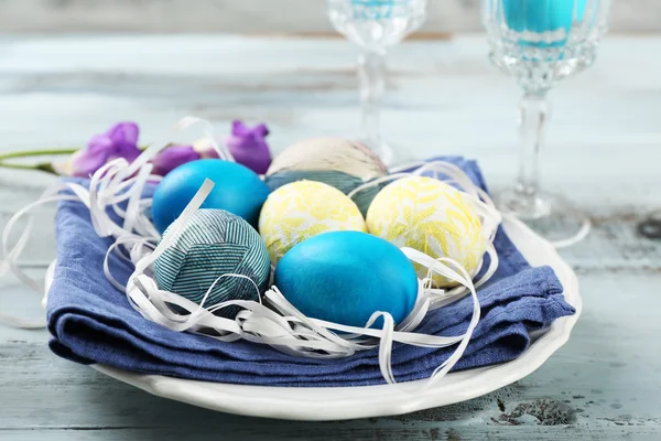 Pasen samenstelling met kleurrijke eieren op servet op houten tafel achtergrond — Stockfoto