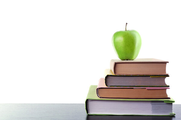 Books and apple on desk, isolated on white