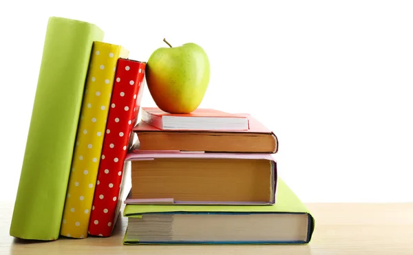 Böcker och apple på skrivbord, isolerad på vit — Stockfoto