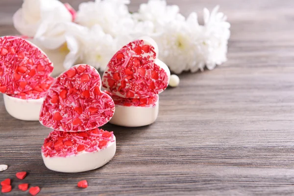 Delicious chocolate candies in heart shape on table close-up — Stock Photo, Image