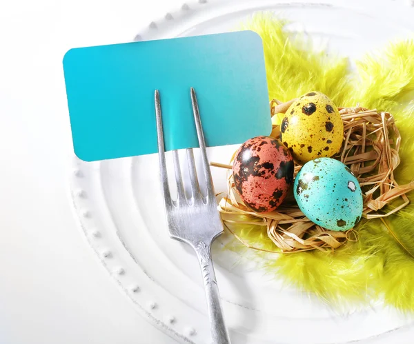 Table de Pâques avec carte vide et œufs de Pâques, isolé sur blanc — Photo