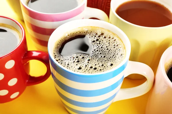 Många koppar kaffe på färgtabell, närbild — Stockfoto