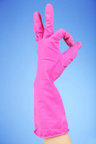 Rubber glove on hand, on blue background — Stock Photo, Image