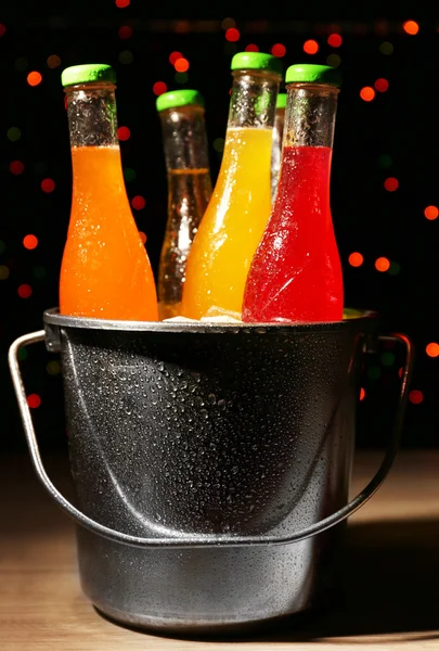 Алкогольные коктейли в металлическом ведре с кубиками льда на темном ярком фоне — стоковое фото