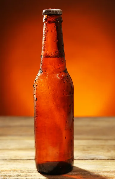 Bouteille de bière en verre sur table en bois sur fond de couleur sombre — Photo