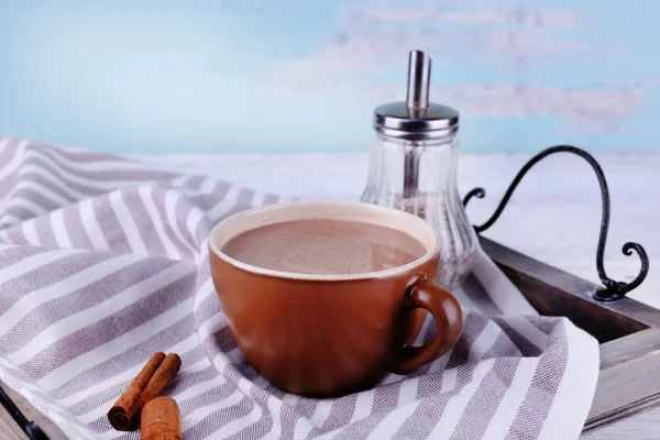 Tazza di cacao con cannella su vassoio e tovagliolo spogliato, primo piano — Foto Stock