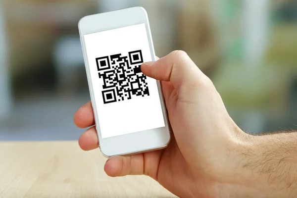 Hand holding smartphone with QR code on the screen — Stock Photo, Image