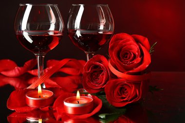 Gözlük, kırmızı gül ve dekoratif merkezinde renkli arka plan üzerinde kırmızı şarap ile kompozisyon