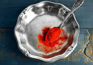 Gümüş tepsi ve renk rustik ahşap masa arka plan üzerinde kırmızı biber kaşığı