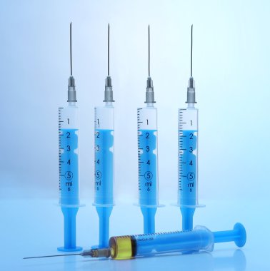 Şırınga ilaç üzerinde mavi arka plan ile