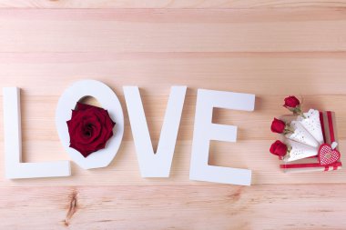 Kelime aşk ile güzel güller ve ahşap plakalar arka plan üzerinde mevcut kutusu