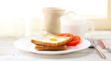 Ekmek ile çay ışık arka plan üzerinde plaka üzerinde yumurtayla karıştırılmış