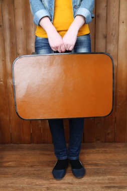 Eski çanta ahşap arka plan üzerinde tutan kadın