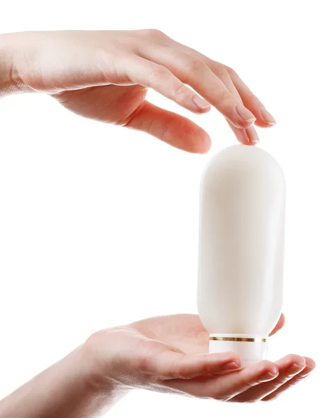 Mãos femininas com garrafa de cosméticos isolados em branco — Fotografia de Stock