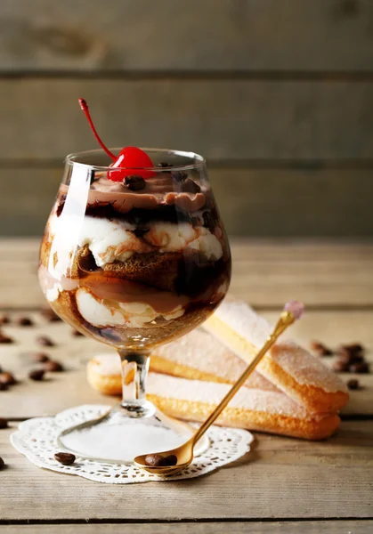 Lekkere tiramisu dessert in glas, op houten achtergrond — Stockfoto