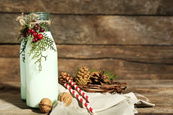 Bottles of fresh milk with natural decor, on wooden background — Stock Photo, Image