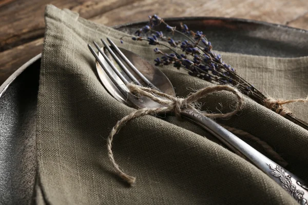 Argenterie attachée avec corde sur plateau en métal avec toile de jute et fleur séchée sur des planches en bois — Photo