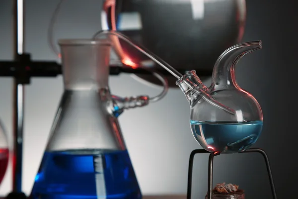 Fixed laboratory glassware on support on dark colorful background