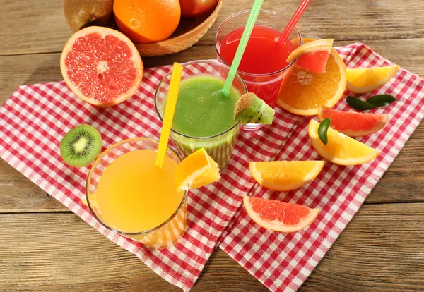 Jugos frescos con frutas en mesa de madera —  Fotos de Stock