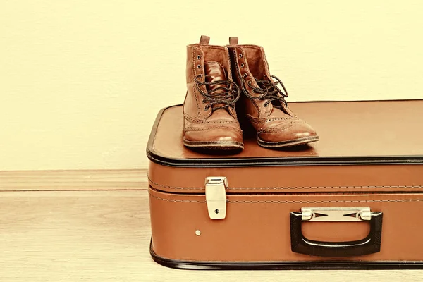 Vintage koffer met mannelijke schoenen op verdieping op lichte muur achtergrond — Stockfoto