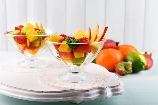 Ovocný salát s mátou v sklo na dřevěný stůl a prkna pozadí — Stock fotografie