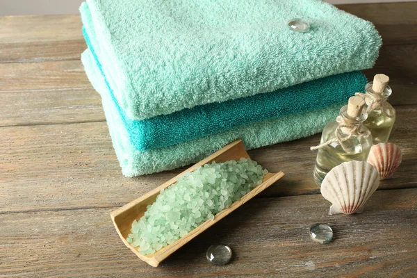 Spa composition with towels and sea salt on wooden table — Stock Photo, Image