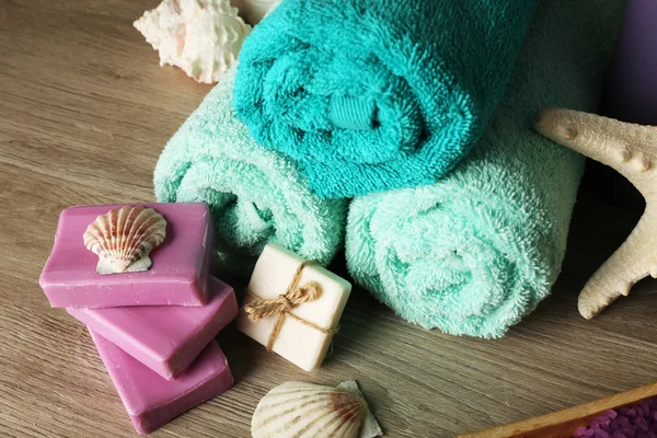 Spa sammansättning med handdukar och tvål på trä bakgrund — Stockfoto