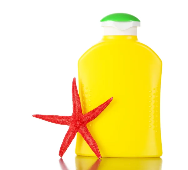 Botella de crema bronceadora con estrella de mar aislada en blanco — Foto de Stock