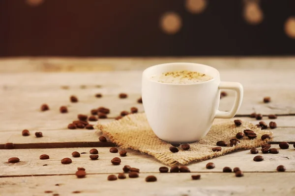 Filiżankę kawy na stole na brązowym tle — Zdjęcie stockowe