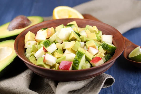 Salad with apple and avocado in bowl with napkin on table close up — Stock Photo, Image