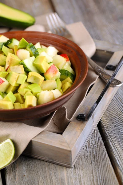 Insalata con mela e avocado in ciotola su vassoio sul tavolo da vicino — Foto Stock