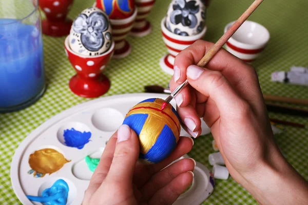 Mujer joven pintando huevos de Pascua en la mesa de cerca —  Fotos de Stock