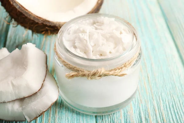 Fresh coconut oil in glassware on color wooden table background — Stock Photo, Image